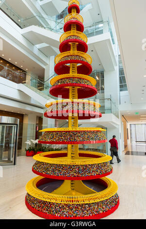 Un arbre de Noël fait de milliers de personnages Lego dans un immeuble de bureaux hall. Banque D'Images