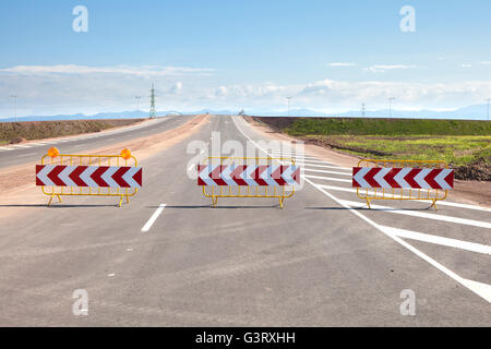 Trois barrières de signalisation en bordure d'une nouvelle route en construction. Banque D'Images