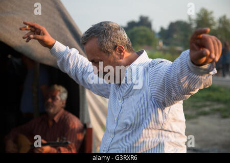 Un homme danse syrienne kurde dans Idomeni camp de réfugiés en Grèce, près de la frontière macédonienne. Banque D'Images
