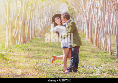 Jeune homme romantique asai et femme debout et s'étreindre mutuellement avec tendresse sur le terrain. Young Love concept. Banque D'Images