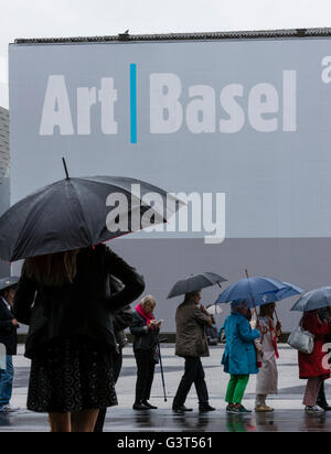 Bâle, Suisse. 14 Juin, 2016. Les visiteurs font la queue sous la pluie battante à l'extérieur du parc des expositions de Bâle à l'ouverture de 'Art Basel 2016', une des plus grandes et plus spectaculaires rencontres pour l'art moderne et contemporain pour les six jours, 280 salles seront montrer des œuvres de 4000 artistes. En 2015, le salon de Bâle, qui a également des ramifications à Hong Kong et à Miami, a attiré 98 000 visiteurs du monde entier. Crédit : Erik Tham/Alamy Live News Banque D'Images