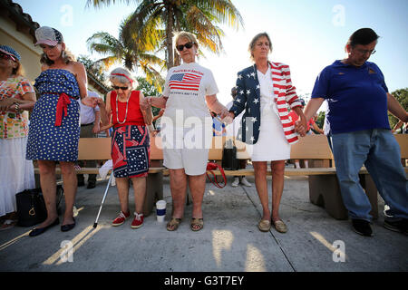 En Floride, aux États-Unis. 14 Juin, 2016. Les membres de l'auditoire tenir la main et observer un moment de silence pour les victimes de la prise de masse à Orlando lors d'une célébration du Jour du drapeau dans le kiosque à Lake Worth's Bryant Park Mardi, 14 juin, 2016. En fonction de la ville de Lake Worth's website, ''Lake Worth a été officiellement constitué en 1912, et en janvier de cette année l'avenue Lake est devenue la première à être classés et secoué. Comme la ville a commencé à se développer, les résidents ont vu la nécessité de construire un quai au pied de l'avenue Lake qui a 1 000 pieds dans le Lake Worth Lagoon. Peu après Bryant P Banque D'Images