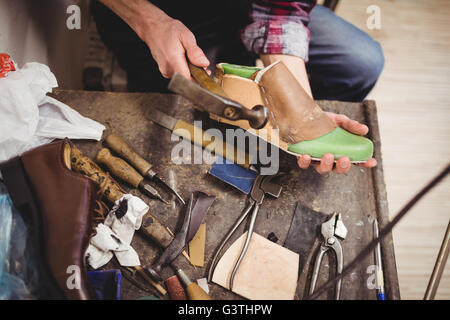 High angle view of hands hammering sur une chaussure Banque D'Images