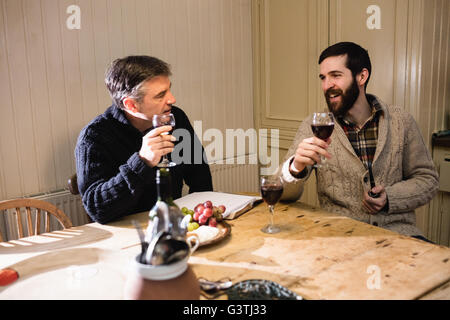 Hipster et homme mûr ayant une discussion tout en buvant du vin rouge Banque D'Images