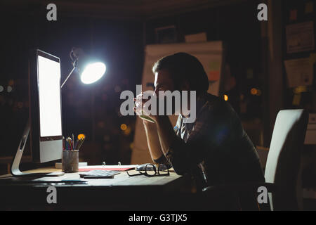 Businessman drinking coffee at night Banque D'Images