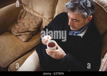 Homme de boire une tasse de thé tout en vous relaxant Banque D'Images