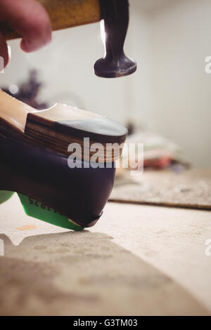 Close up of hand marteler sur le talon d'une chaussure Banque D'Images