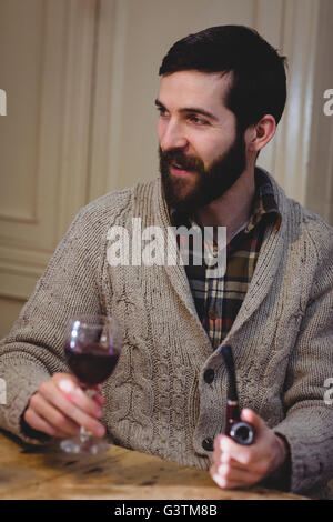 Hipster attrayant drinking Red Wine et pipe Banque D'Images