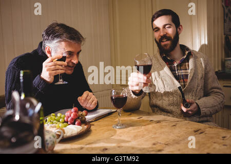 Hipster et homme mûr ayant une discussion tout en buvant du vin rouge Banque D'Images