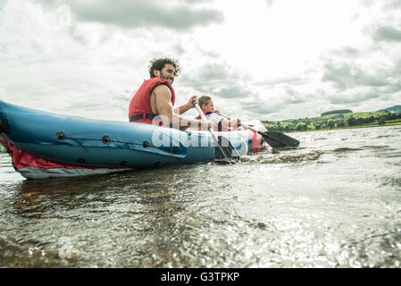 Un homme et un garçon dans un kayak à la rive, sur le lac Bala au Pays de Galles. Banque D'Images