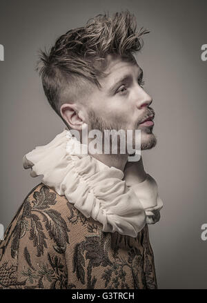 Portrait d'un jeune homme de profil portant une chemise avec un col plumeuse. Banque D'Images