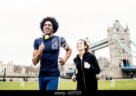 Un jeune couple jogging ensemble passé le Tower Bridge à Londres. Banque D'Images