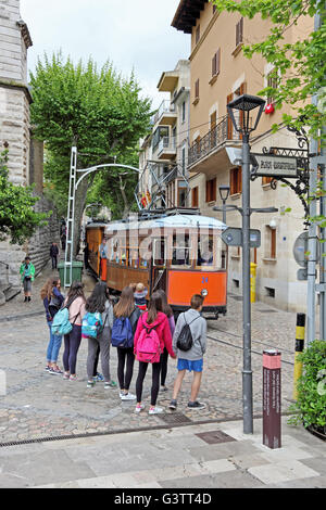 Les jeunes gens à l'écoute du Port de Soller tram passant par Soller, Majorque Banque D'Images