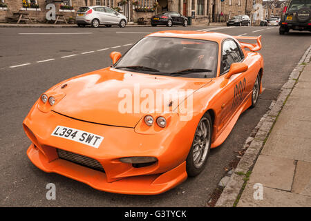 Mazda RX7 de couleur orange sports voiture stationnée dans le village de Middleton-in-Teesdale,fr,Durham Angleterre Banque D'Images