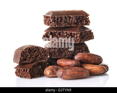 Morceaux de chocolat poreux et les fèves de cacao sur un fond blanc close up Banque D'Images