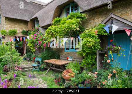 Chaumière et jardin avec bunting. En vertu de l'Ashton Hill, Wychavon District, Worcestershire, Royaume-Uni Banque D'Images