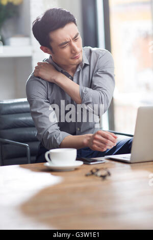Jeune homme fatigué working in office Banque D'Images