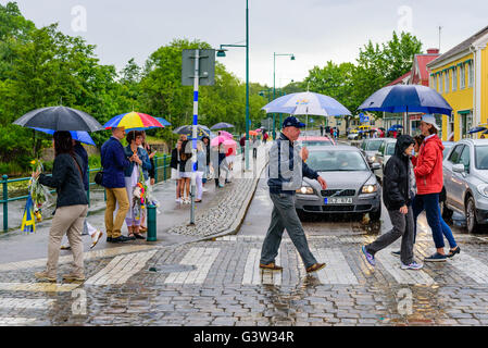 Ronneby, Suède - le 10 juin 2016 : les gens marcher dans une rue en ville au milieu d'une pluie. La circulation a arrêté et Banque D'Images