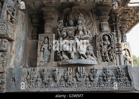 Sculptures sur la façade, côté ouest murs. shiva-parvati. hoysaleshwara temple, halebidu, Karnataka, Inde. vue depuis l'ouest. Banque D'Images