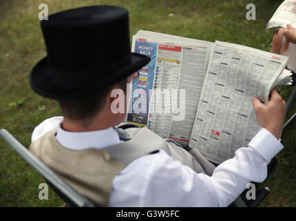 Un Racegoer vérifie la forme au cours de la deuxième journée du Royal Ascot, 2016 à Ascot Racecourse. Banque D'Images