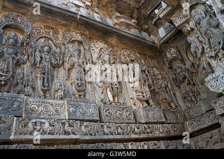 Panneau mural orné reliefs représentant des divinités hindoues, côté ouest, temple hoysaleshwara, halebidu, Karnataka, Inde. Banque D'Images