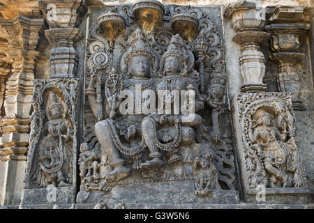 Sculptures sur la façade, côté ouest murs. shiva-parvati. hoysaleshwara temple, halebidu, Karnataka, Inde. vue depuis l'ouest. Banque D'Images