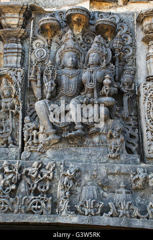 Sculptures sur la façade, côté ouest murs. shiva-parvati. hoysaleshwara temple, halebidu, Karnataka, Inde. Banque D'Images