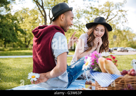 Playful young couple having picnic et flirting in park Banque D'Images
