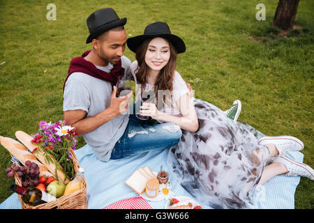 Hand couple jeune vigne potable sur la pelouse au parc d'été Banque D'Images