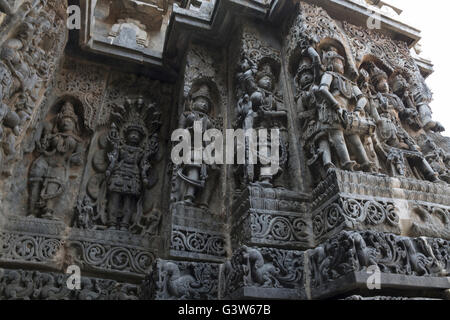 Panneau mural orné reliefs représentant des divinités hindoues, côté ouest, temple hoysaleshwara, halebidu, Karnataka, Inde. Banque D'Images