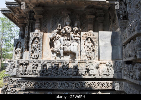 Sculptures sur la façade, côté ouest murs. shiva-parvati assis sur nandi. hoysaleshwara temple, halebidu, Karnataka, Inde. Banque D'Images