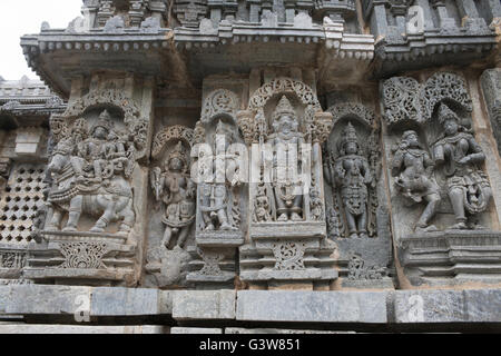 Panneau mural relief représentant (de gauche) Shiva-Parvati, Brahma et les autres divinités, mur nord, Kedareshwara, temple Halebid, Inde Banque D'Images