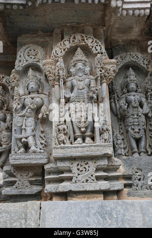 Panneau mural bas-reliefs représentant brahma dans le centre et d'autres déités, mur nord, kedareshwara temple, halebidu, Inde Banque D'Images