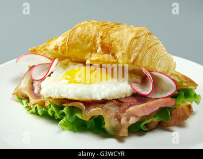 Matin d'été Petit-déjeuner Croissant fourré des œufs brouillés et bacon frit Banque D'Images