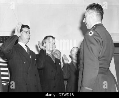 Joe DiMaggio, gauche, ancien voltigeur home run king et de la NY Yankees, est assermenté dans l'armée américaine avec d'autres membres par le Capt M.A. Branson, droit, à un centre d'initiation sur la côte ouest. L'induction de Joe diminue son revenu à partir d'un salaire de base de 50 000 $ par année pour les 50$ par mois en tant que l'argent privé. Banque D'Images