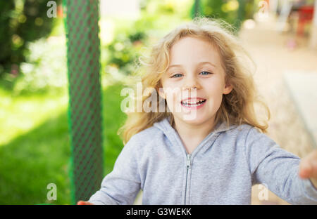 Outdoor portrait of cute smiling little blond girl Banque D'Images