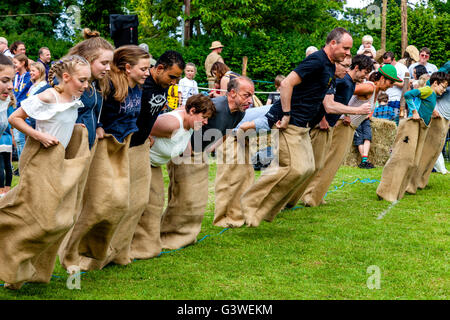 Adolescents et adultes, dans un sac de course à la course traditionnelle foire médiévale de Abinger, Surrey, UK Banque D'Images