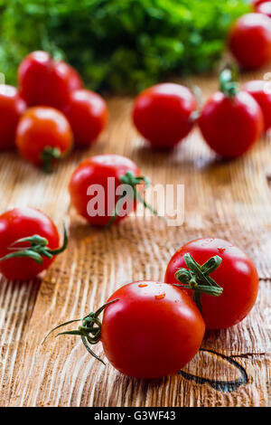 Petites tomates cerise sur fond de bois, selective focus Banque D'Images