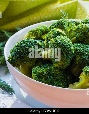 L'alimentation saine : Brocoli bouilli dans un bol blanc sur une table de cuisine. Banque D'Images