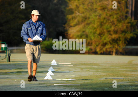 La mise en place du support de pyramides de balles de golf sur practice en préparation pour les golfeurs Banque D'Images