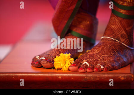 Un rituel lors d'un mariage traditionnel Indien avec une fleur de souci gardé près de les mariées pieds. Banque D'Images