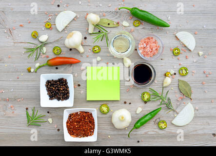 Autocollants colorés en blanc pour les notes et le poivre, le laurier, le romarin, l'oignon, sel, huile d'olive, la sauce de soja sur une table en bois Banque D'Images