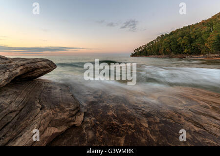 Teintes coucher de la couleur du ciel et des couleurs automnales parsèment la forêt à la plage de mineurs dans la Péninsule Supérieure du Michigan. Munising Banque D'Images