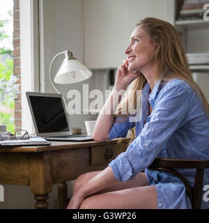 Femme ayant un matin téléphone dans son bureau à domicile Banque D'Images