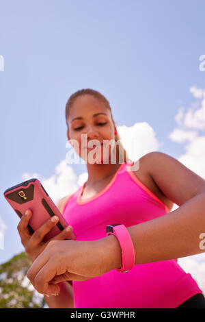 Des jeunes faisant du sport, jogging woman runner fit watch la programmation et la synchronisation des données avec un téléphone mobile wireles Banque D'Images