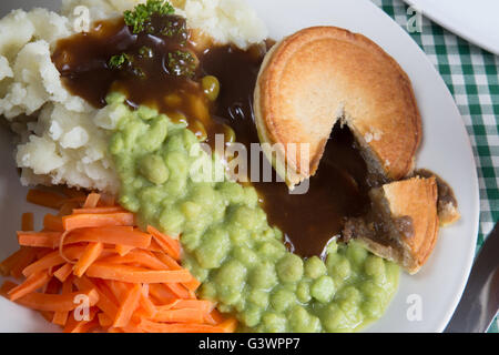 Un plat traditionnel anglais classique de steak Pie, purée de pommes de terre, petits pois et carottes. Servi avec de la sauce. Banque D'Images