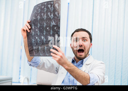 Peur peur médecin examinant à balayage à rayons X à l'appareil photo à l'intérieur in office Banque D'Images