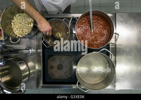 Un cuisinier préparer soupes et sauces pour le déjeuner. Banque D'Images