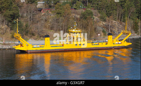 Cargo roro jaune passe près d'une côte de l'île, l'archipel de Stockholm, Suède Banque D'Images