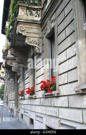 Beaux géraniums rouges sur les rebords de fenêtre, Milan, Italie Banque D'Images